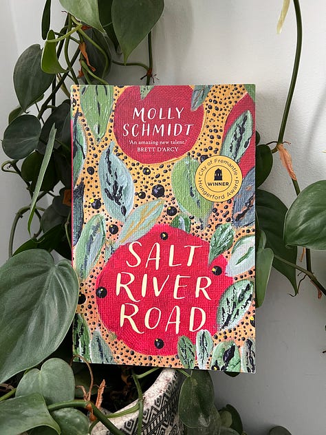 Three novels with colourful covers, set against backdrops of similar colours.