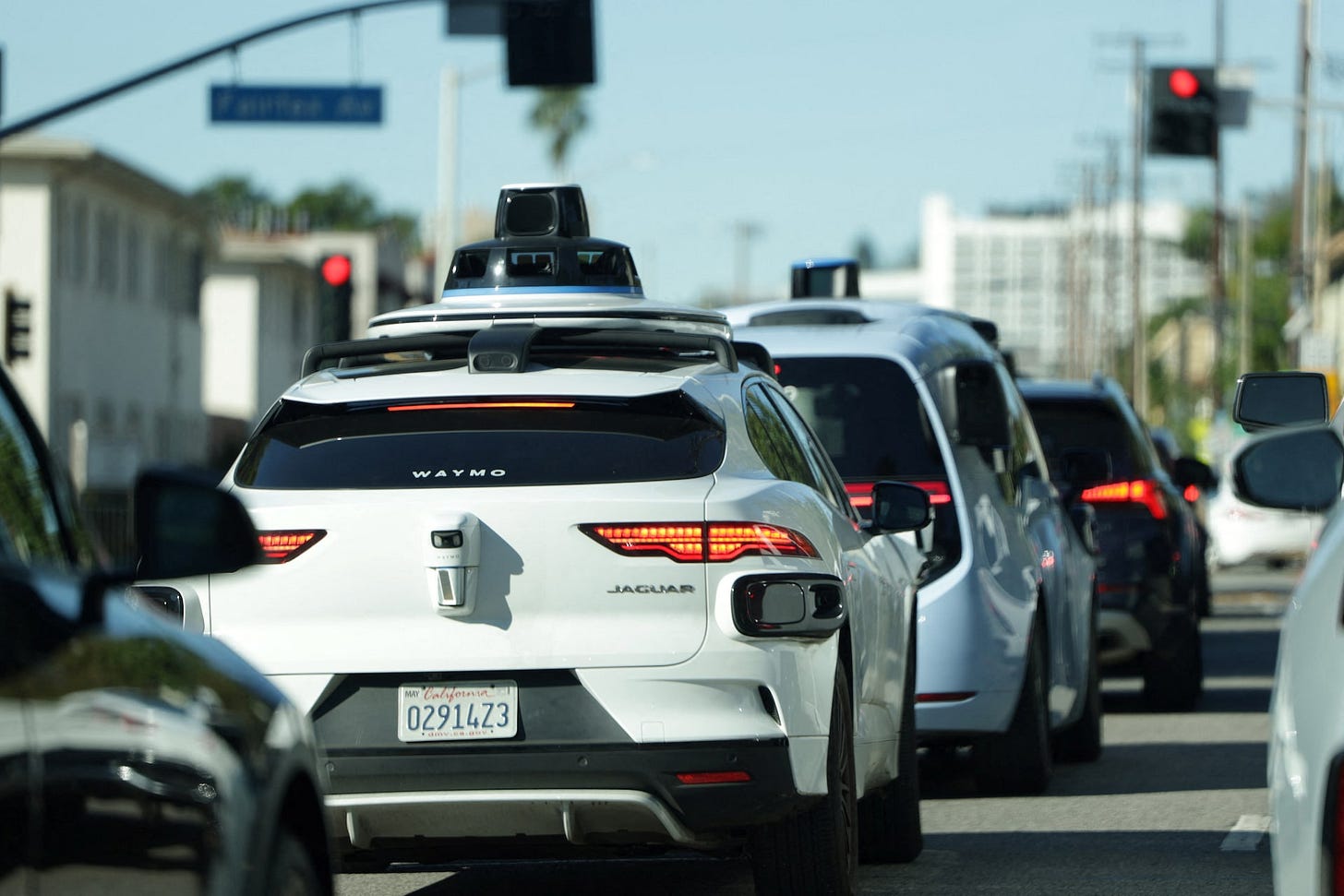 Waymo driverless taxis in traffic in Los Angeles