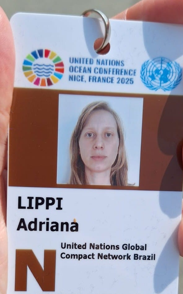 Foto. Crachá com minha foto. Há o logo do evento e das nações unidas no topo