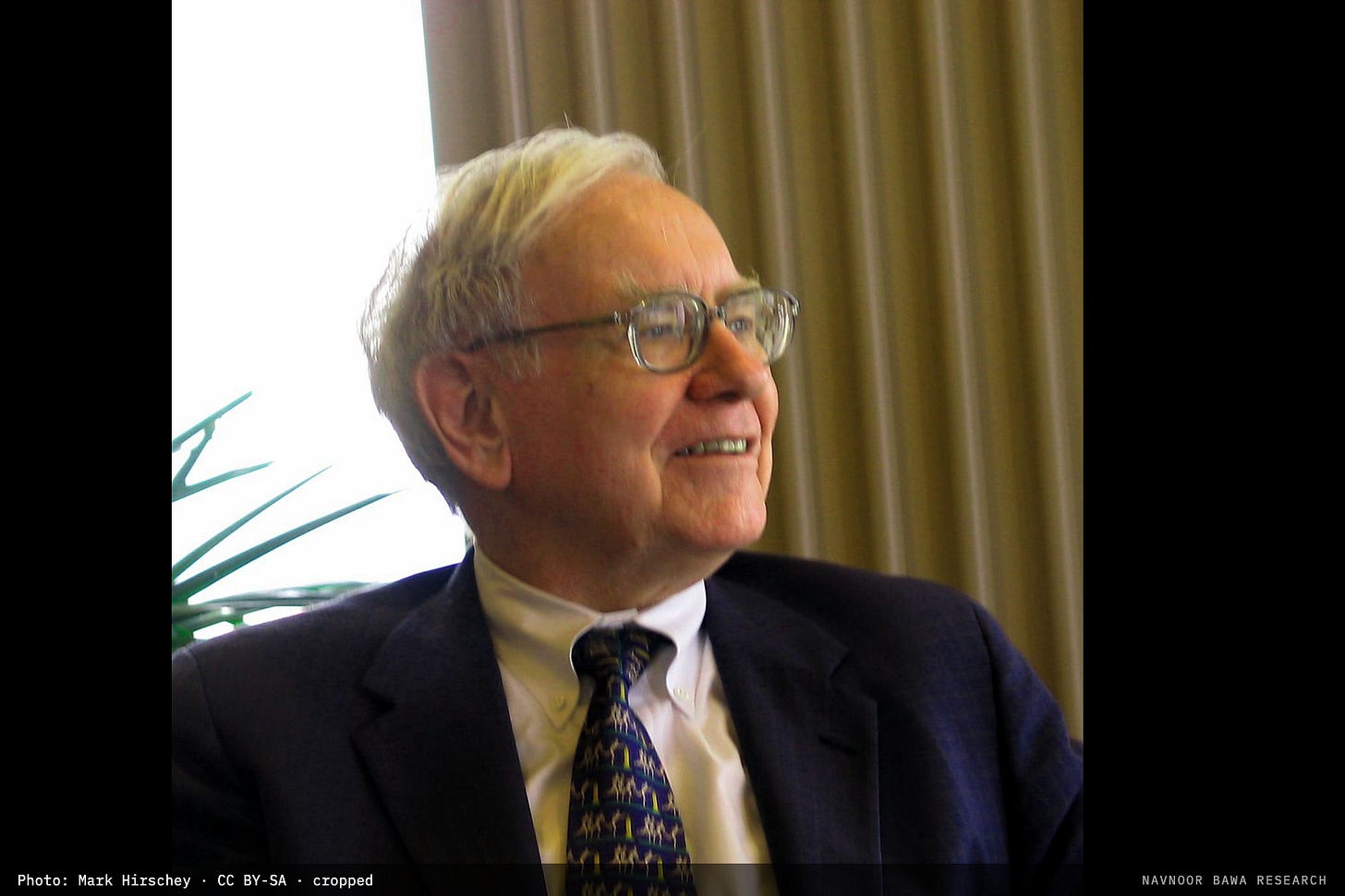 Warren Buffett of Berkshire Hathaway in profile, smiling, against a window and curtain Warren Buffett of Berkshire Hathaway in profile, smiling, against a window and curtain