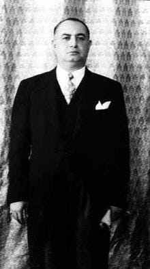 A person in a suit and tie

Description automatically generated