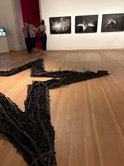 Left: a woman in a lab coat in a video projection narrates the work; Center: the remnants of a burned star from one of Abromovic's earliest installations with black and white photographs of the fire on the wall; Right: the table and star set-up of a live installation when Abromovic carved the star symbol into her abdomen as a performance.