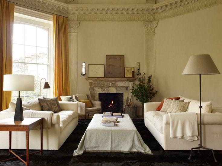 This may contain: a living room filled with furniture and a fire place in the middle of a room
