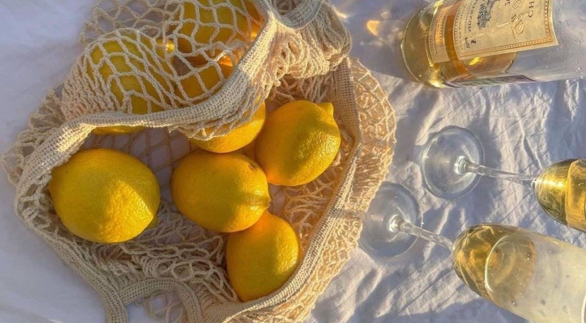 This may contain: four lemons in a bag on a table with wine glasses This may contain: four lemons in a bag on a table with wine glasses