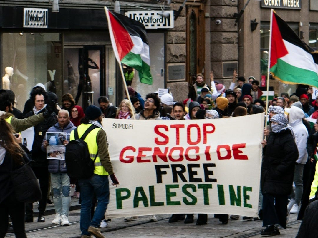 a group of people walking down a street holding flags a group of people walking down a street holding flags
