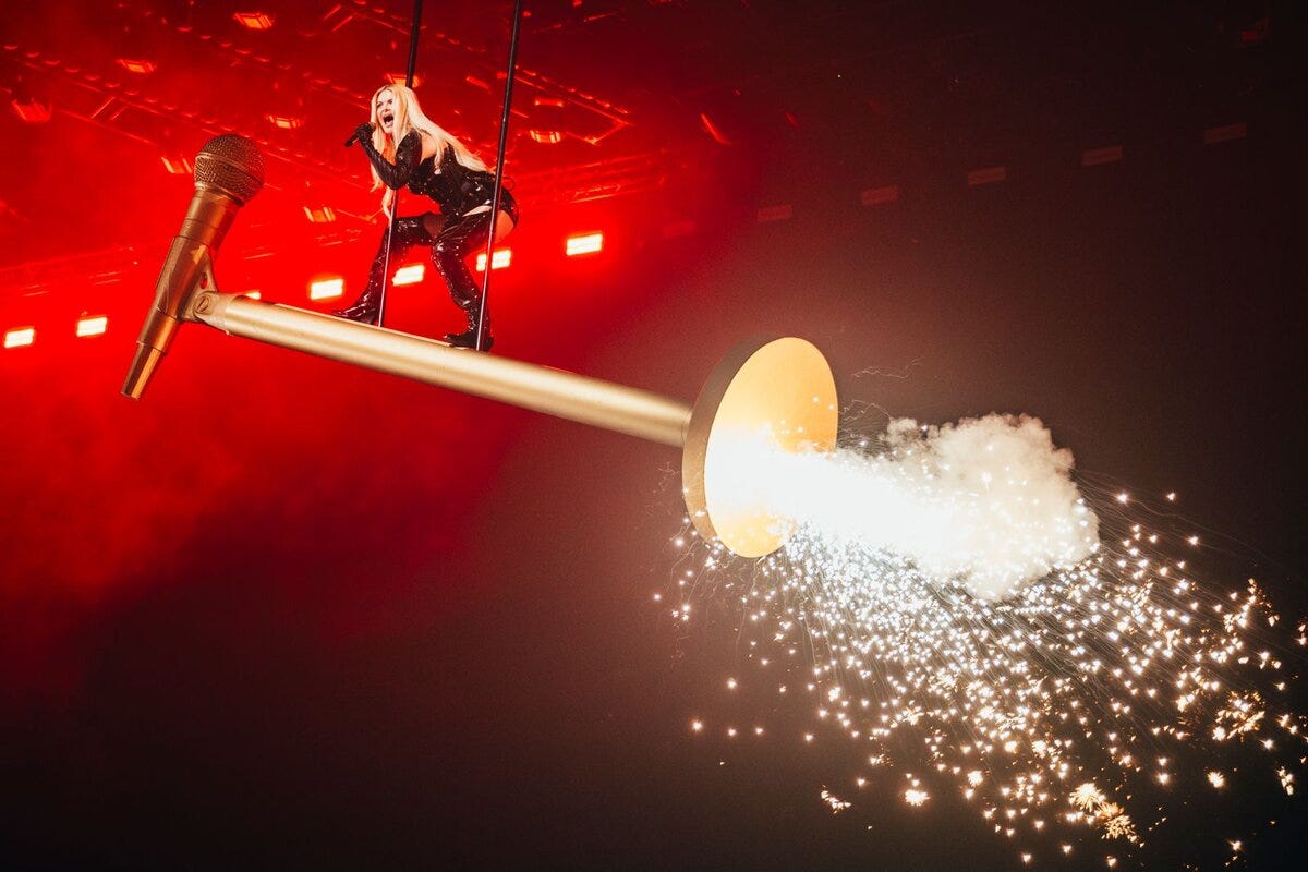 Erika Vikman mounts a giant, sparking microphone during her Eurovision performance of “ICH KOMME.”