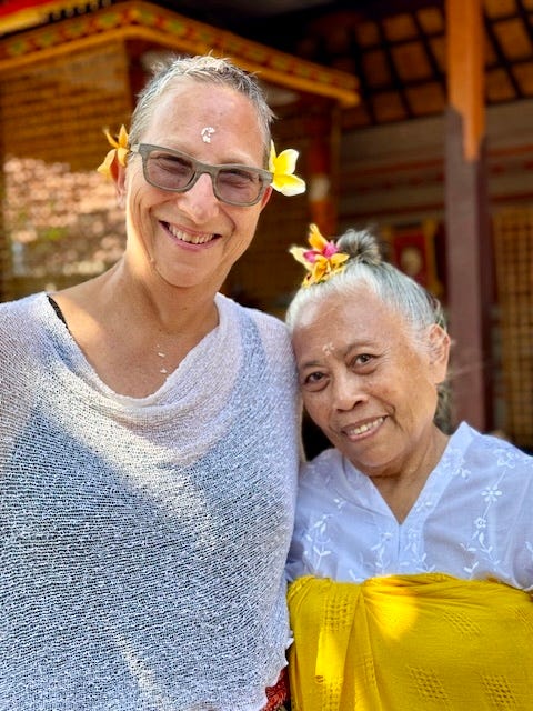 Laura and the high priestess in Bali after being blessed in a water purification ceremony