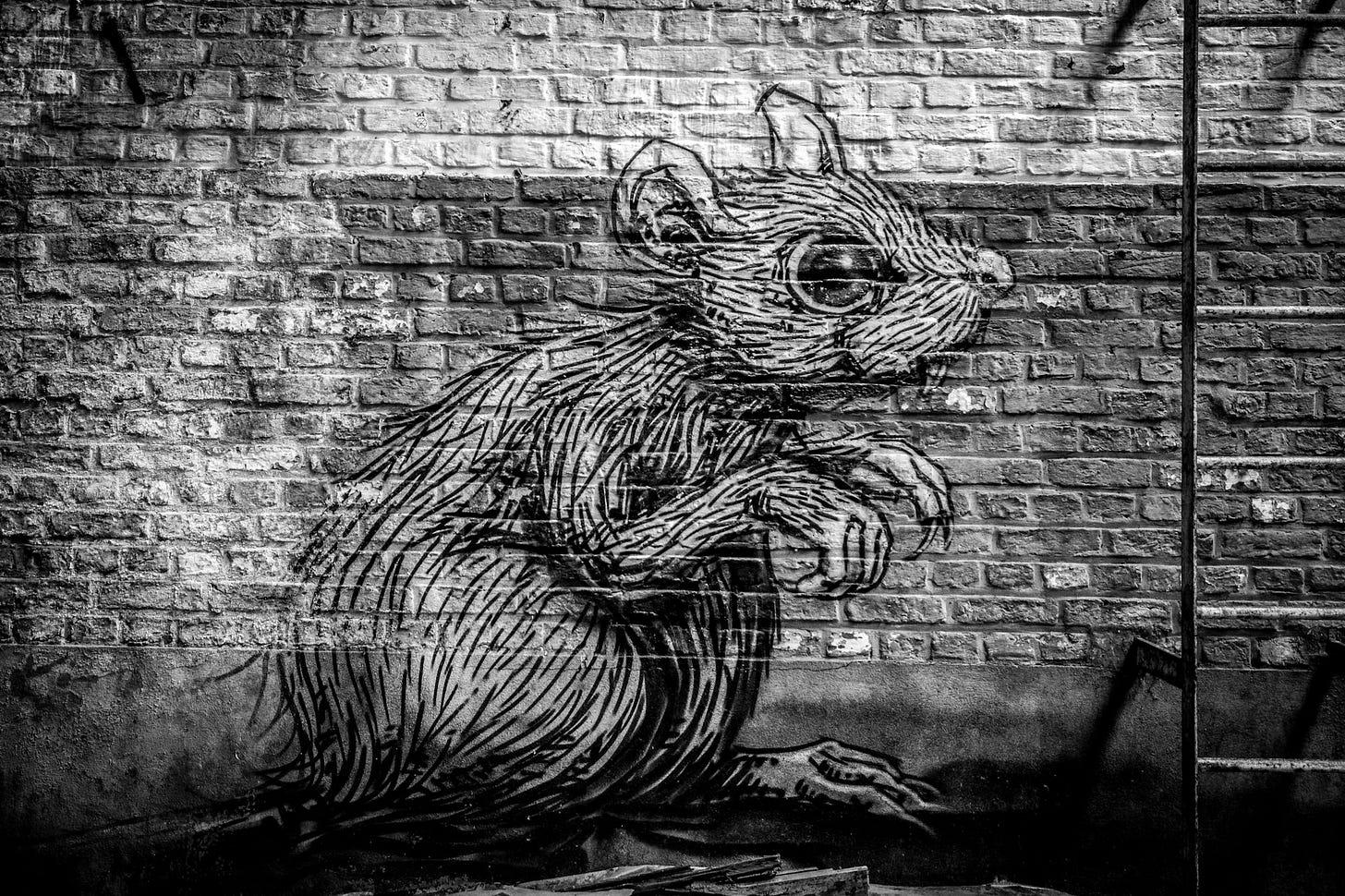 A rat painted on a brick wall