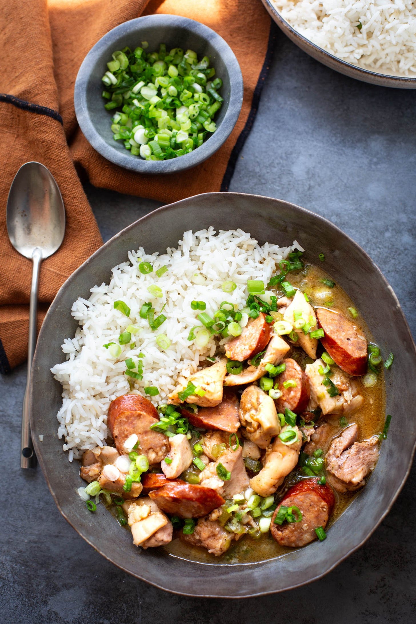 Overhead view of chicken and andouille sausage stew in a grey bowl. Overhead view of chicken and andouille sausage stew in a grey bowl.