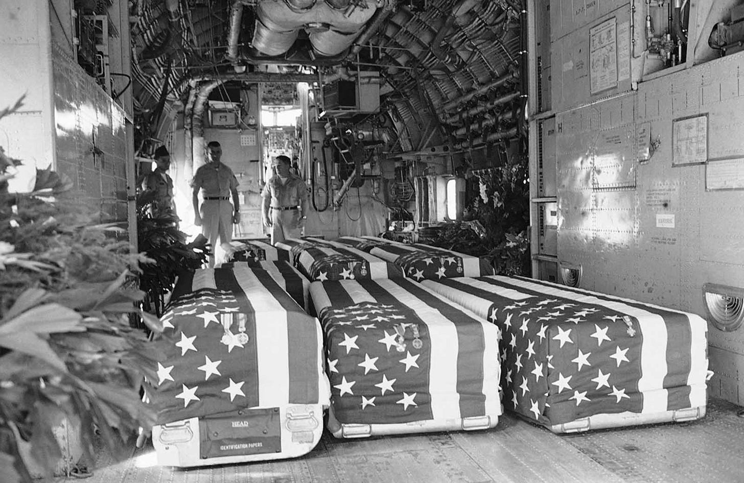 Flag-draped coffins carrying eight American servicemen, killed in Viet Cong attacks on February 7, 1965, are loaded onto a transport plane at Saigon for repatriation, a grim symbol of early U.S. losses. Flag-draped coffins carrying eight American servicemen, killed in Viet Cong attacks on February 7, 1965, are loaded onto a transport plane at Saigon for repatriation, a grim symbol of early U.S. losses.