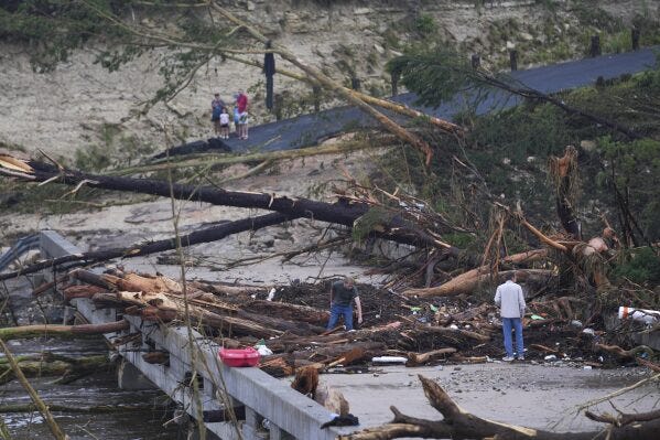 Debris rests on a bridge over the Guadalupe River after a flash flood swept through the area Saturday, July 5, 2025, in Ingram, Texas. (AP Photo/Julio Cortez)