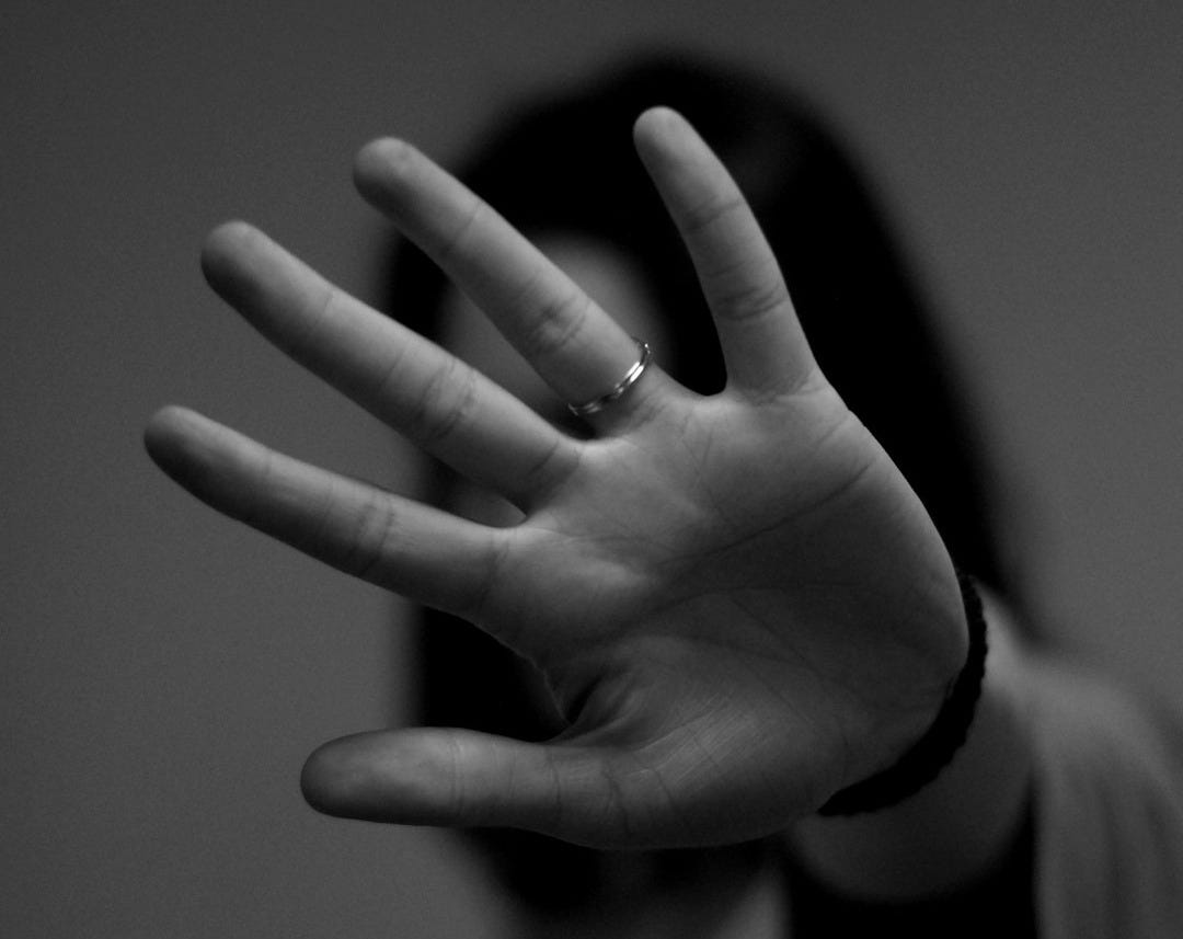 woman showing left hand with wedding band