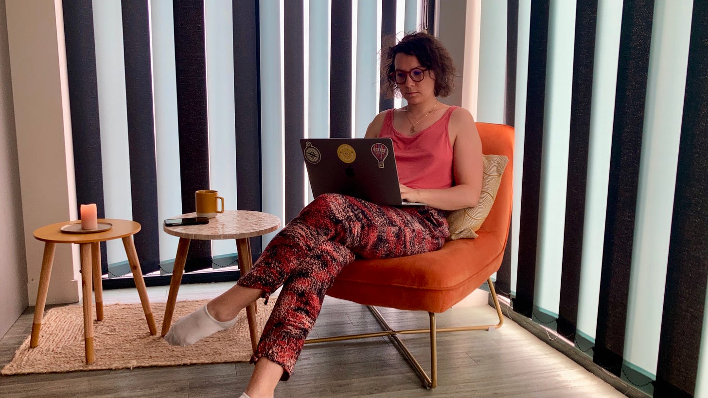 Emilie Thoumoux en train d'écrire à l'ordinateur, assise sur un fauteuil