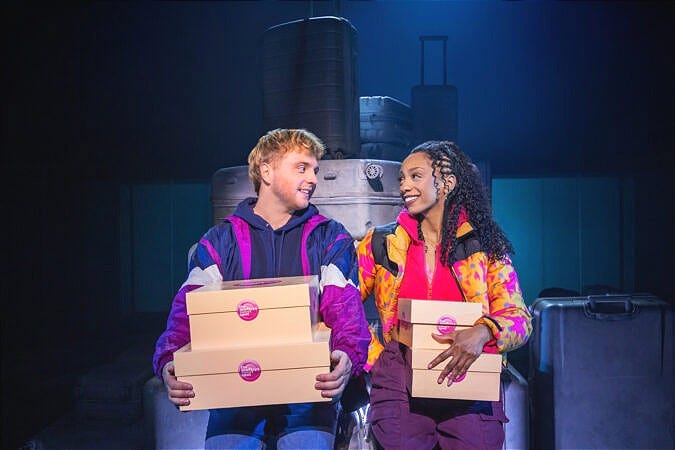 A man and a woman smile at each other while holding cake boxes A man and a woman smile at each other while holding cake boxes