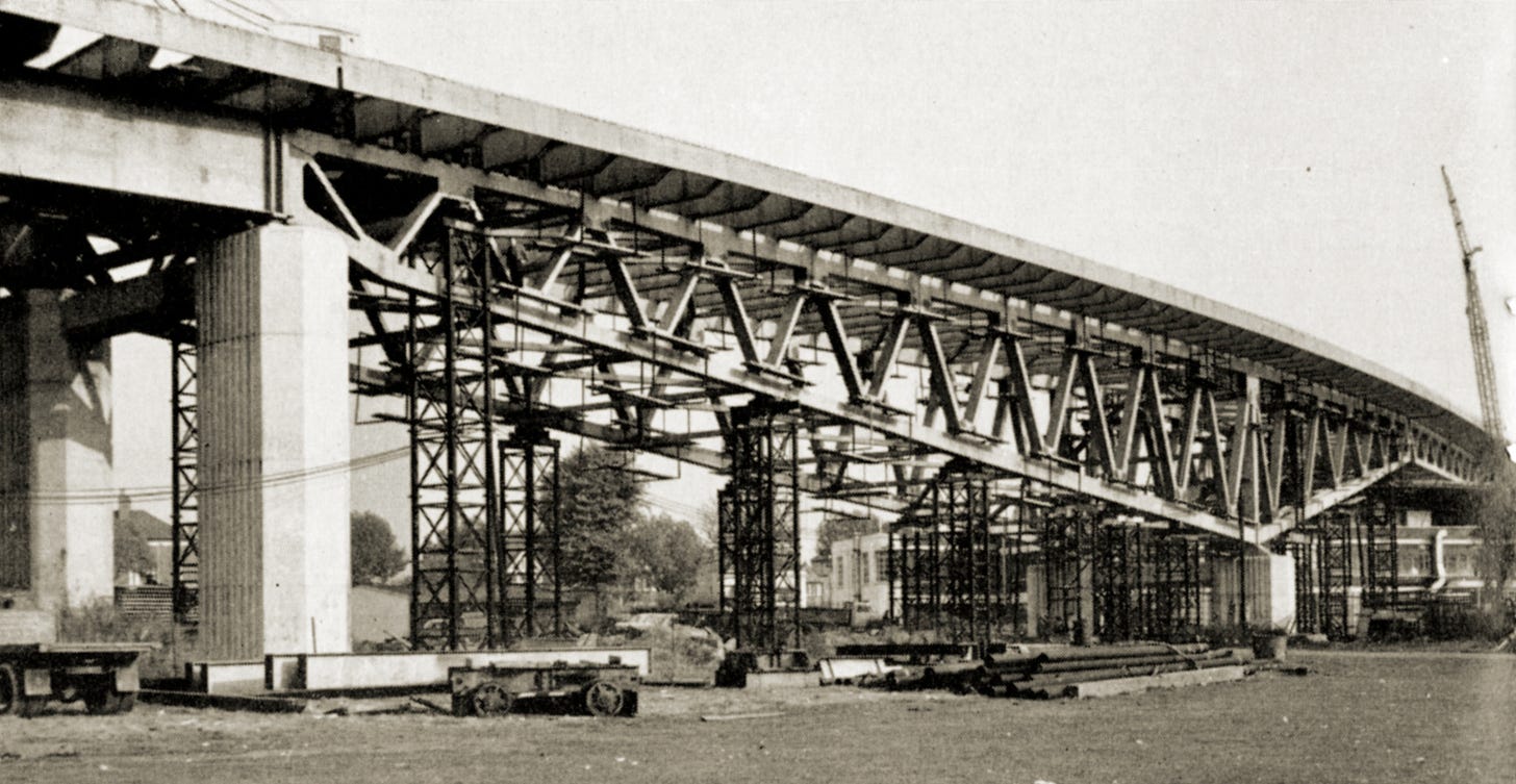 Photograph of a section of viaduct built as a steel truss spanning a long way into the distance. Temporary scaffolding supports the new structure from beneath.