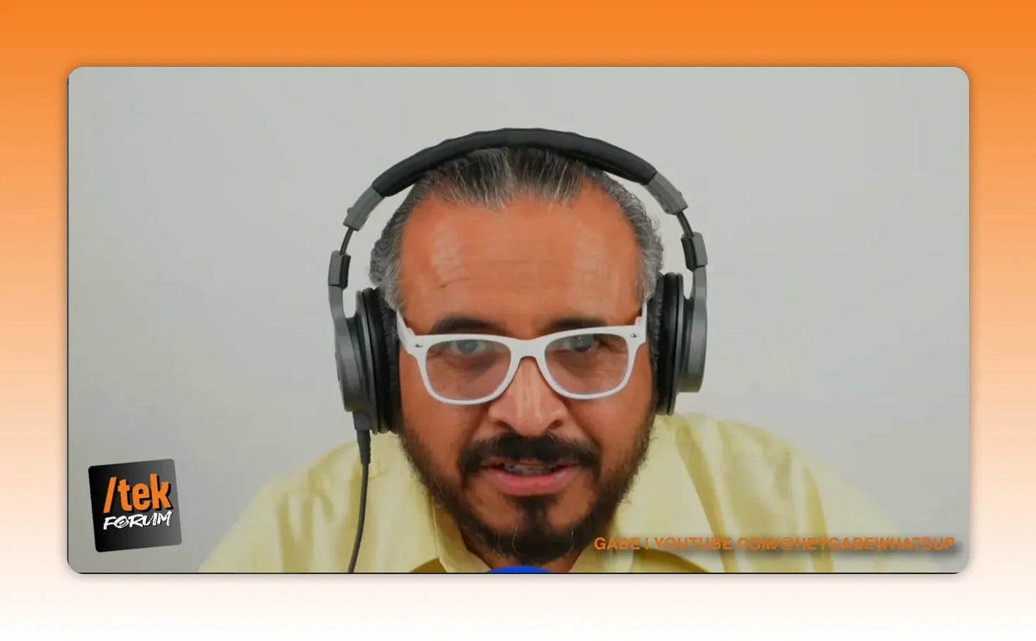 podcast host with headphones and white glasses looking at camera, clear head-and-shoulders shot