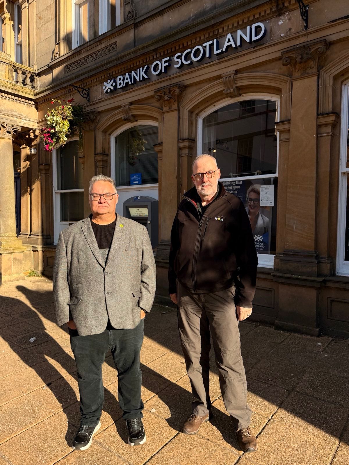 Obligatory photograph of Graham and I looking glum outside the bank