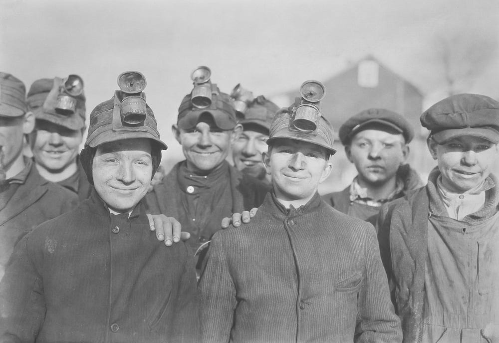 A black and white photograph of coal miners. A black and white photograph of coal miners.