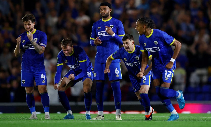 Five Wimbledon players celebrate winning their 2nd Round Carabao Cup Tie against Ipswich on pens