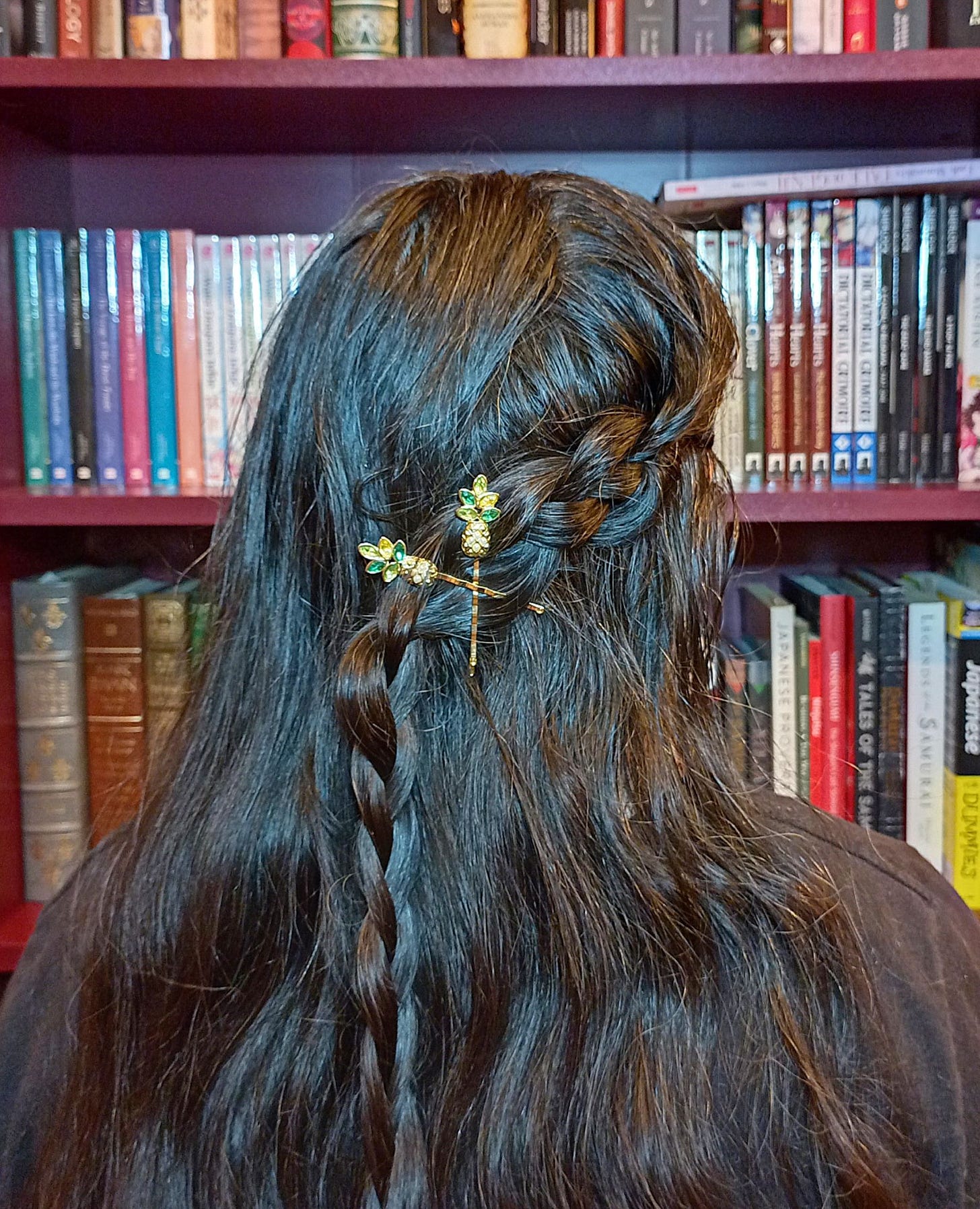 Woman with long brown hair wearing crossed bobby pins in a braid