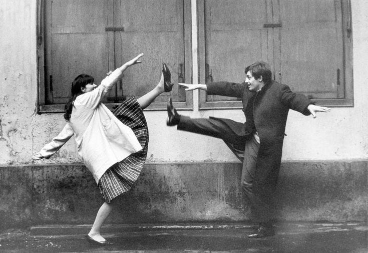 This may contain: two people are dancing in front of a window with their arms stretched out and legs spread wide