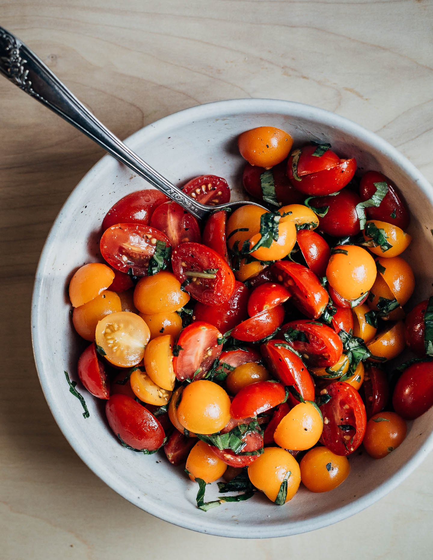 A bowl with colorful tomatoes and basil