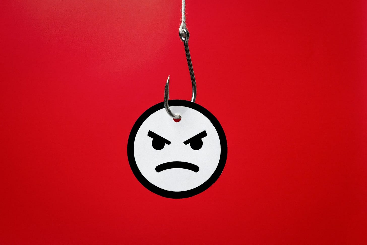 A grimacing face dangling on a fishhook