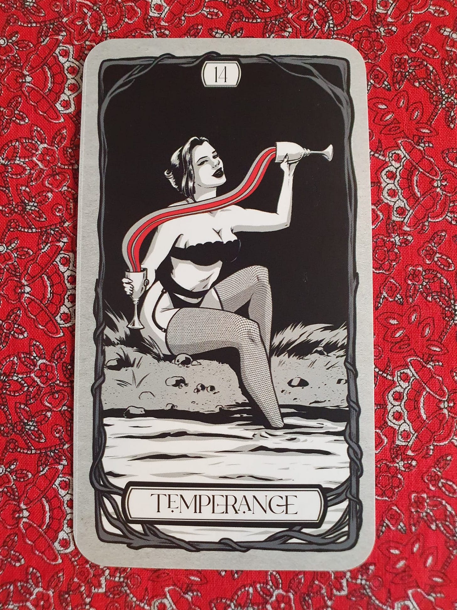 Temperance card from Michelle Lodge’s Bad Witch Tarot, showing a woman pouring liquid between two goblets beside water. Temperance card from Michelle Lodge’s Bad Witch Tarot, showing a woman pouring liquid between two goblets beside water.