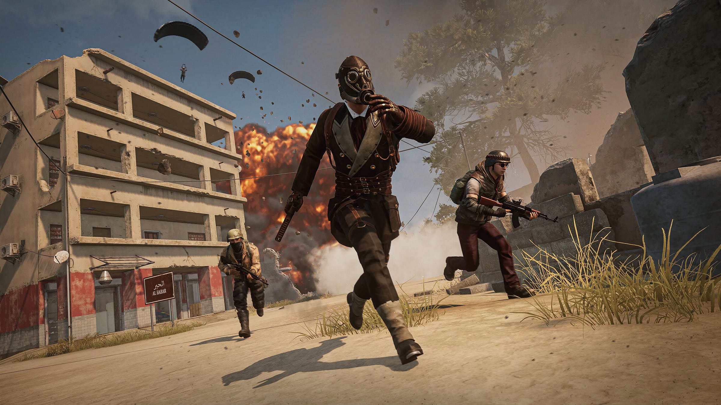 Video game screenshot of a person in a gas mask walking away from a building. An explosion erupts in the background and people are parachuting from the sky