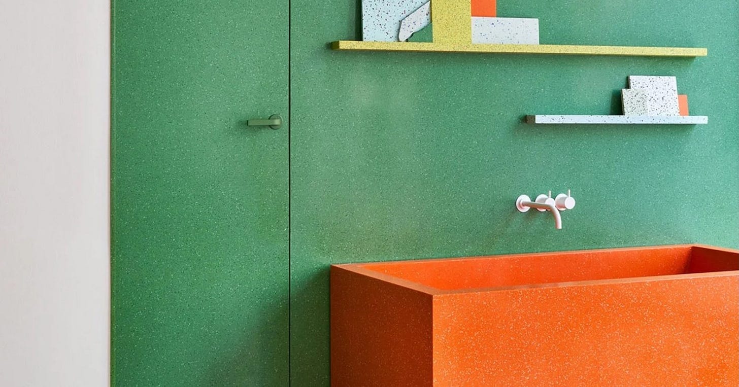 Orange soaking tub set against an apple-green wall in the Durat showroom Orange soaking tub set against an apple-green wall in the Durat showroom