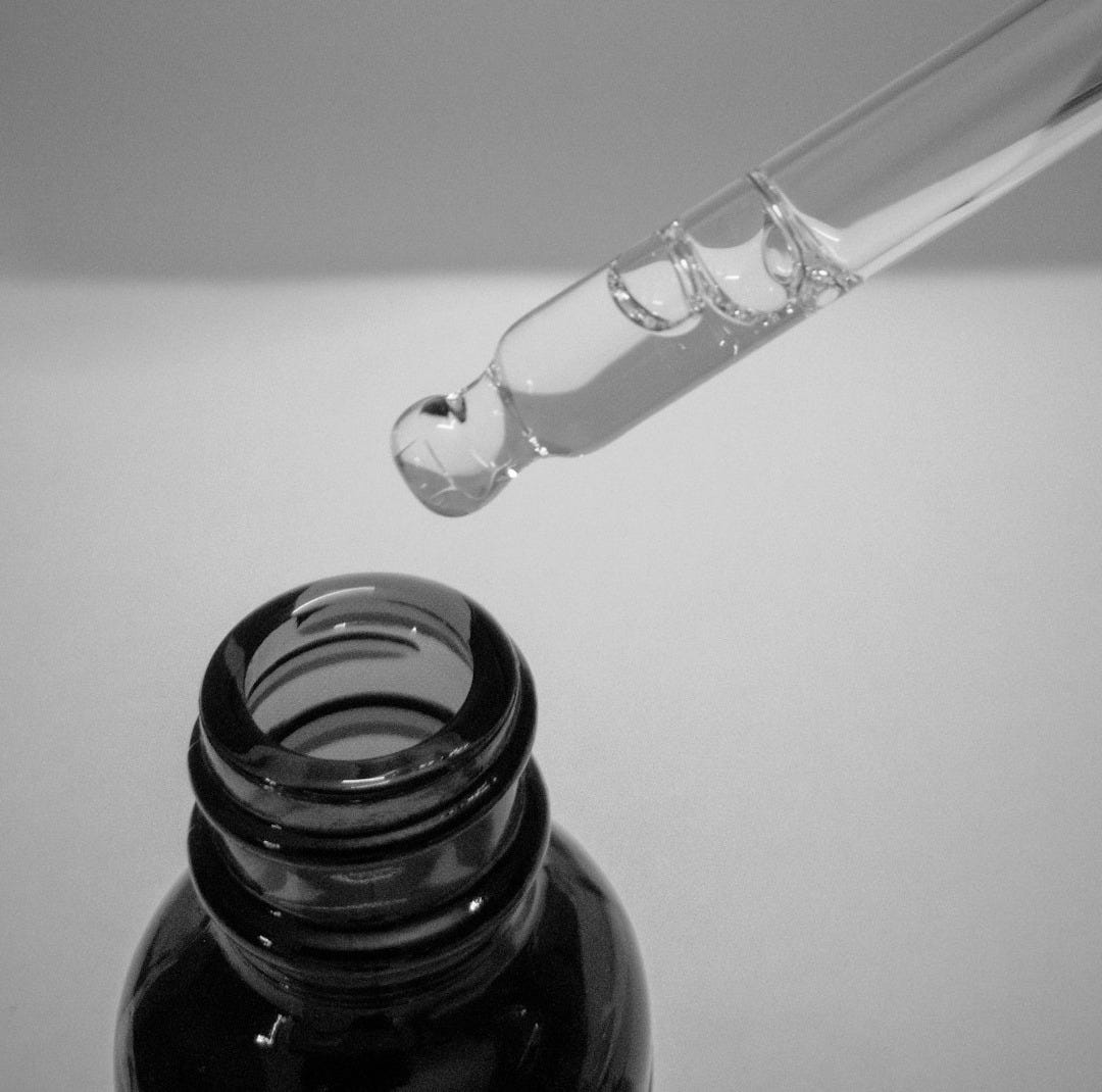 a glass bottle with a liquid inside of it a glass bottle with a liquid inside of it