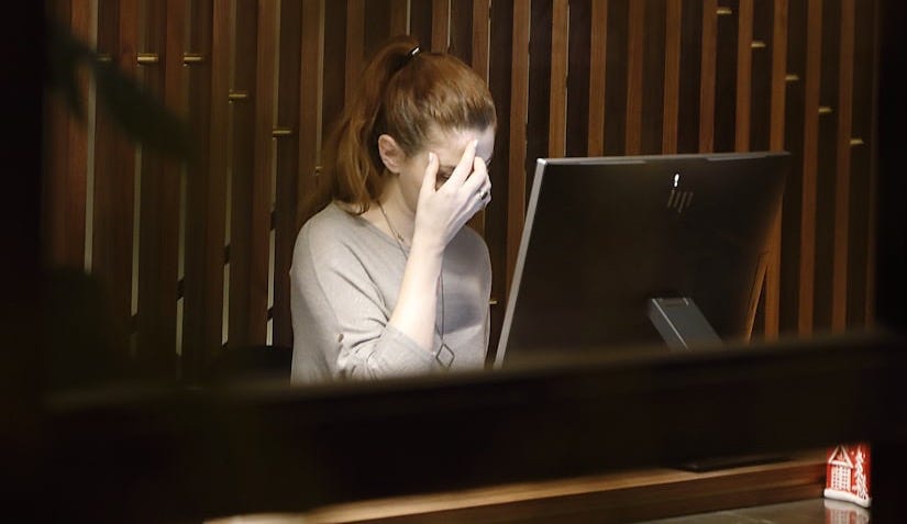 a woman sitting in front of a laptop computer a woman sitting in front of a laptop computer