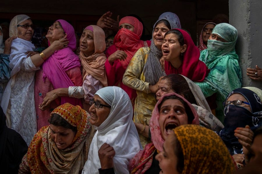 More than a dozen women hold each other and cry aloud.