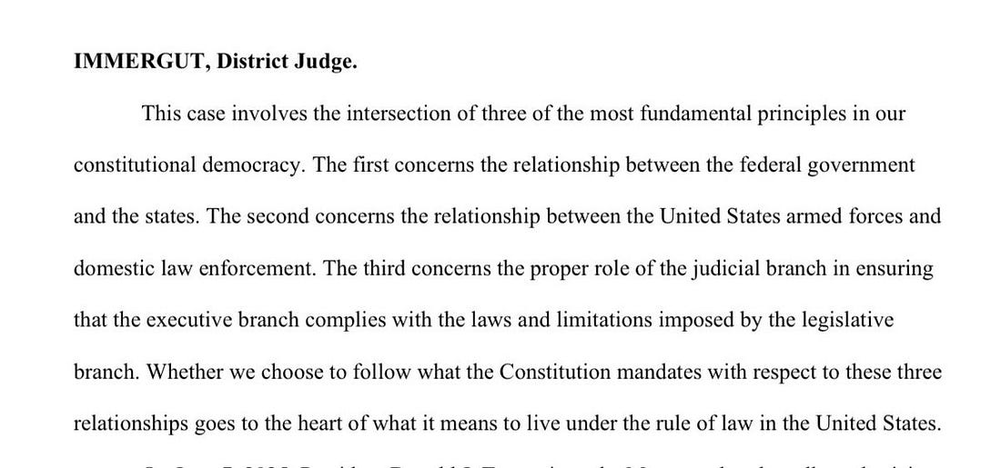A document with text from Judge Immergut, District Judge. The text discusses constitutional democracy, the relationship between federal government and states, the United States armed forces and domestic law enforcement, and the judicial branch ensuring executive branch compliance with laws and limitations.