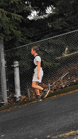 Brian walking backwards up a hill wearing a weighted vest. Brian walking backwards up a hill wearing a weighted vest.