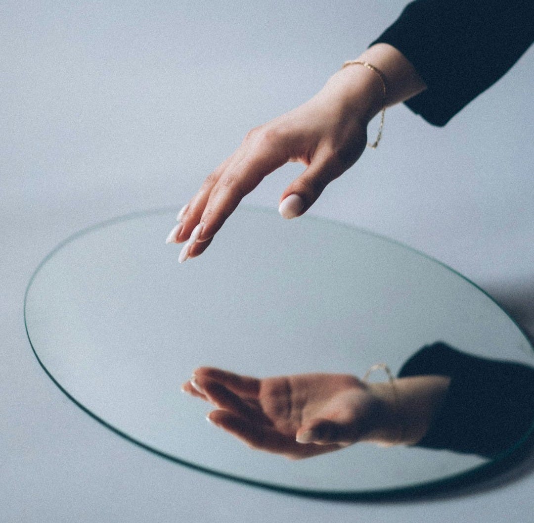 person in black long sleeve shirt holding round glass