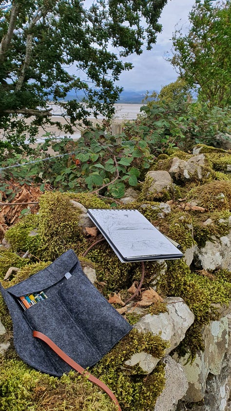 1st Pic. Watercolour sketching kit and paper on a railing looking out towards the mountains. 2nd pic. A park bench looking across a lake. Painting kit all set out ready for a painting session. 3rd pic. Sketching kit of pencils and a small pocket size sketchbook on a dry stone wall in the autumn time.