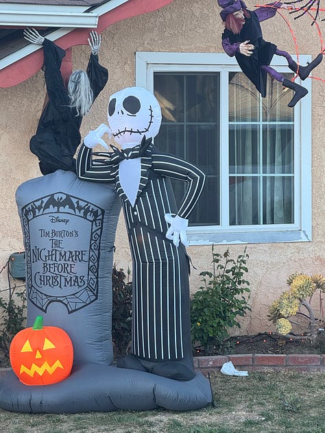 Various Halloween displays--including witches, skeletons, spiders, and a talking medieval knight--in front yards along Santa Paula Street.