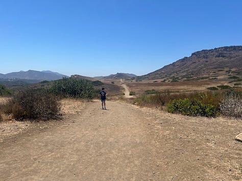 Photos of a desert hike featuring pictures of brown landscape, a waterfall, the author, a teepee, and a fence post with a quote on it.
