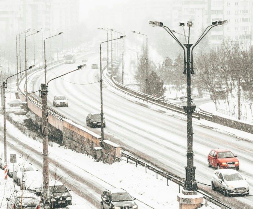 aerial view of road coated snow with vehicle passes