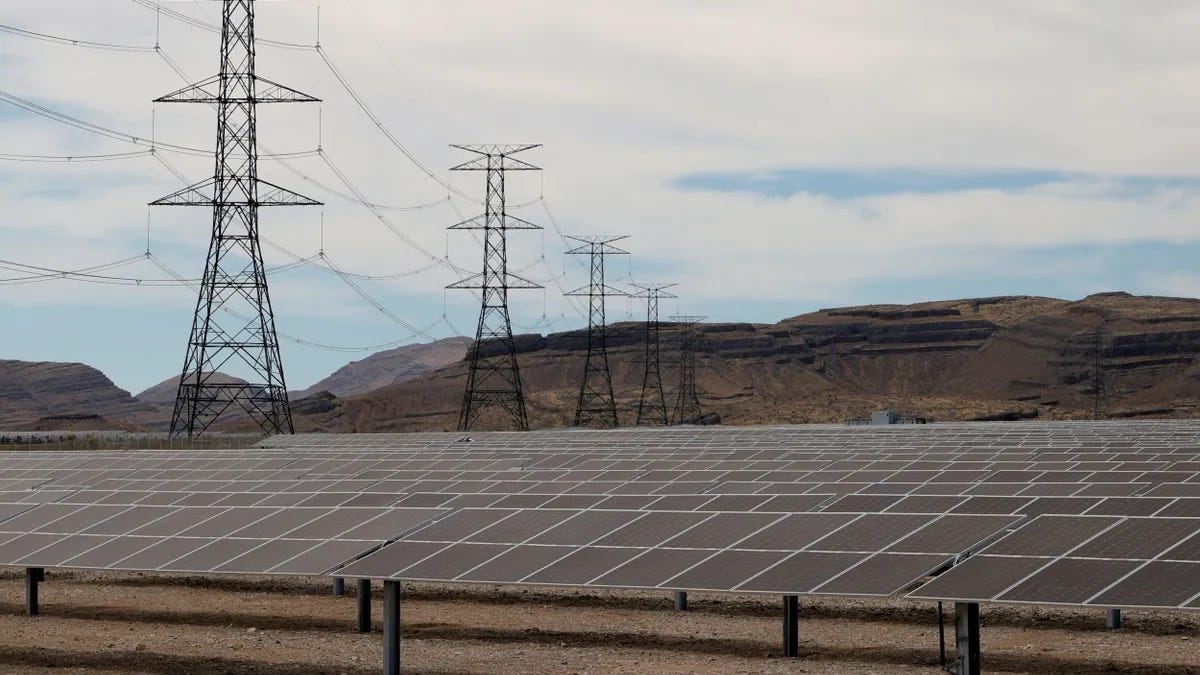 Transmission towers are shown near solar panels