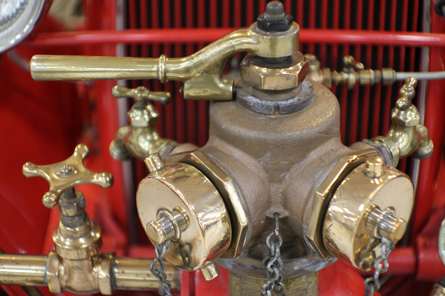 Water valve on top of a fire truck. The valve is made of metal and has two large outlets where fire hoses can be attached. Water valve on top of a fire truck. The valve is made of metal and has two large outlets where fire hoses can be attached.