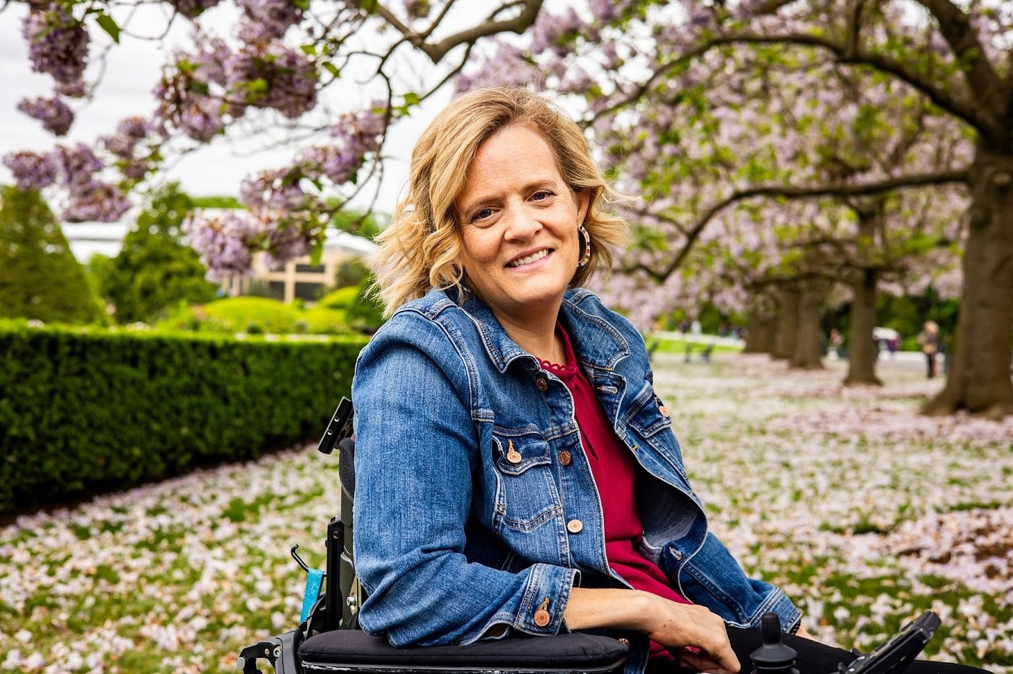 Katie is a fair skinned, disabled woman seated in a power wheelchair. Katie is a fair skinned, disabled woman seated in a power wheelchair.