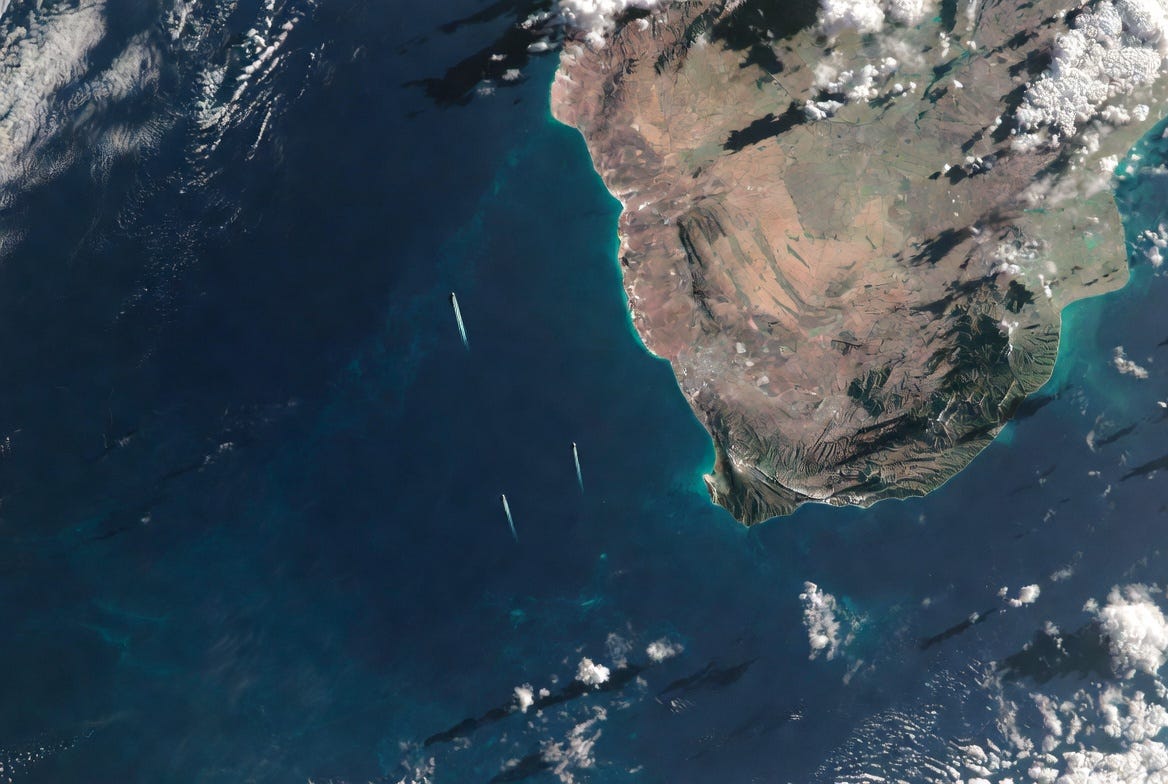 Aerial satellite view of coastal island with turquoise waters and mountainous terrain Aerial satellite view of coastal island with turquoise waters and mountainous terrain