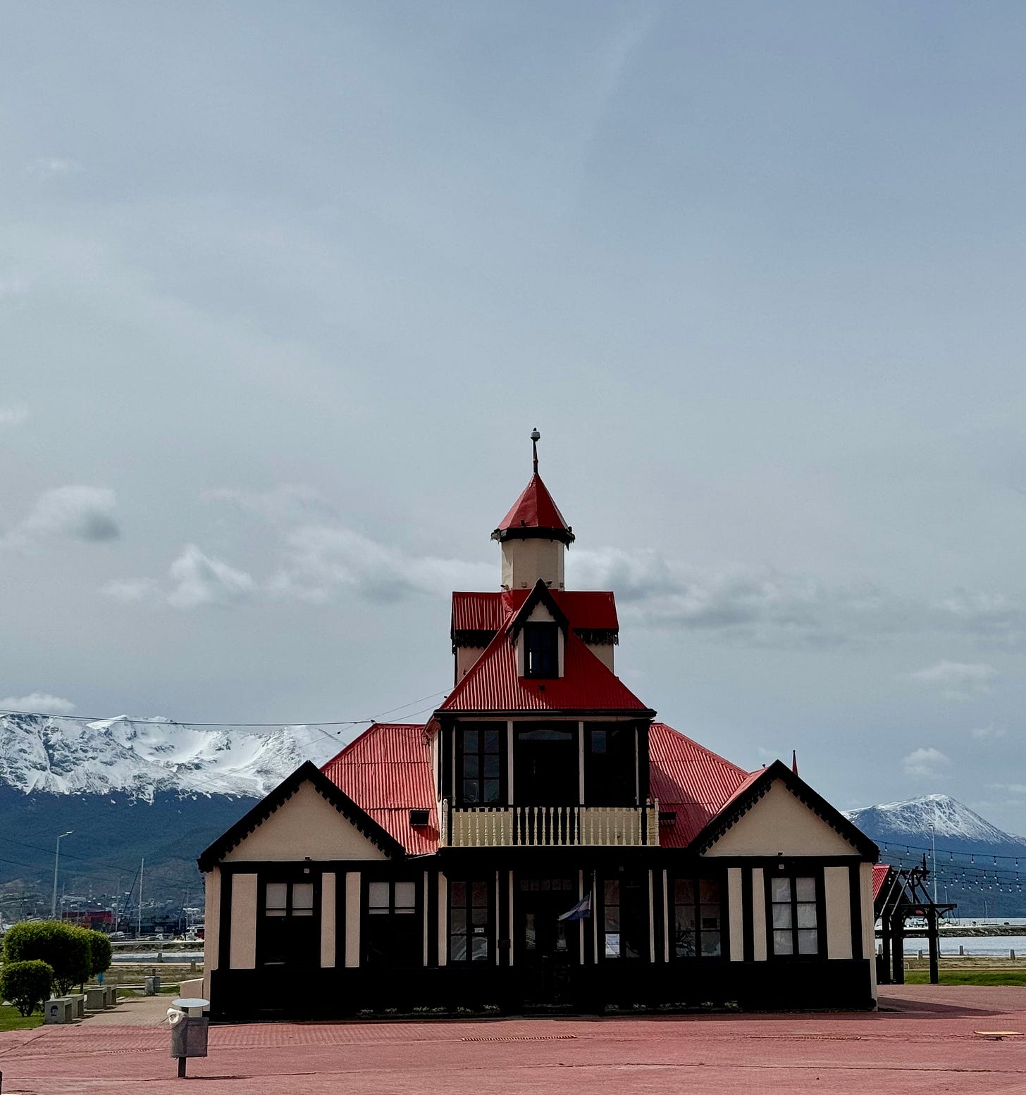 Casa en Ushuaia con tejado rojo y montañas nevadas al fondo. Foto propia.
