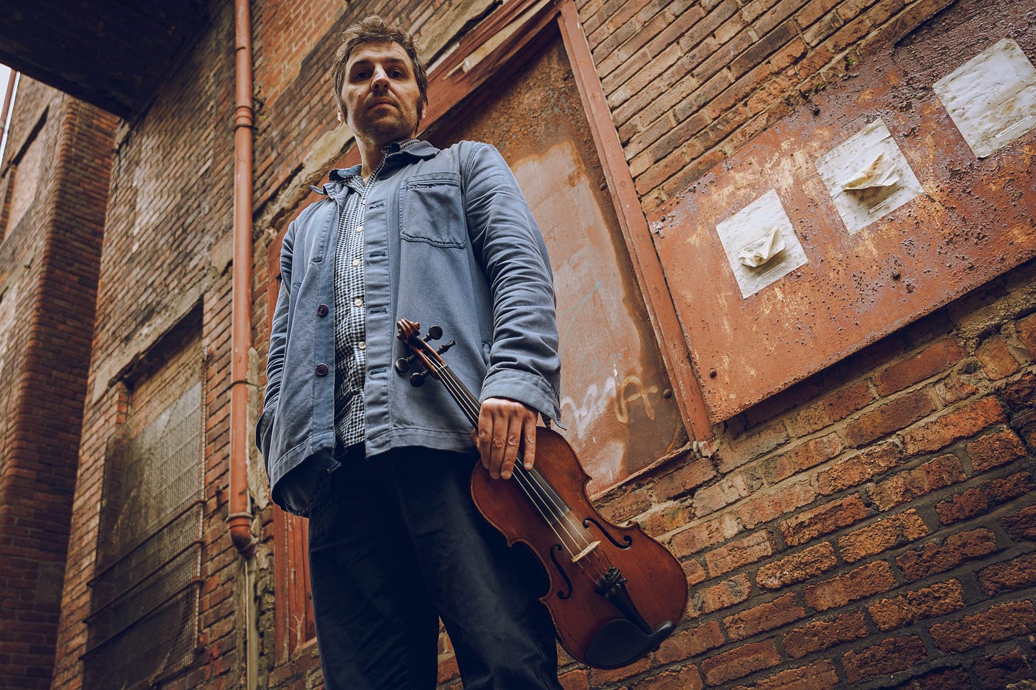 A photo of Mikey Kenney, taken from below, as though the photographer was laying on the street.