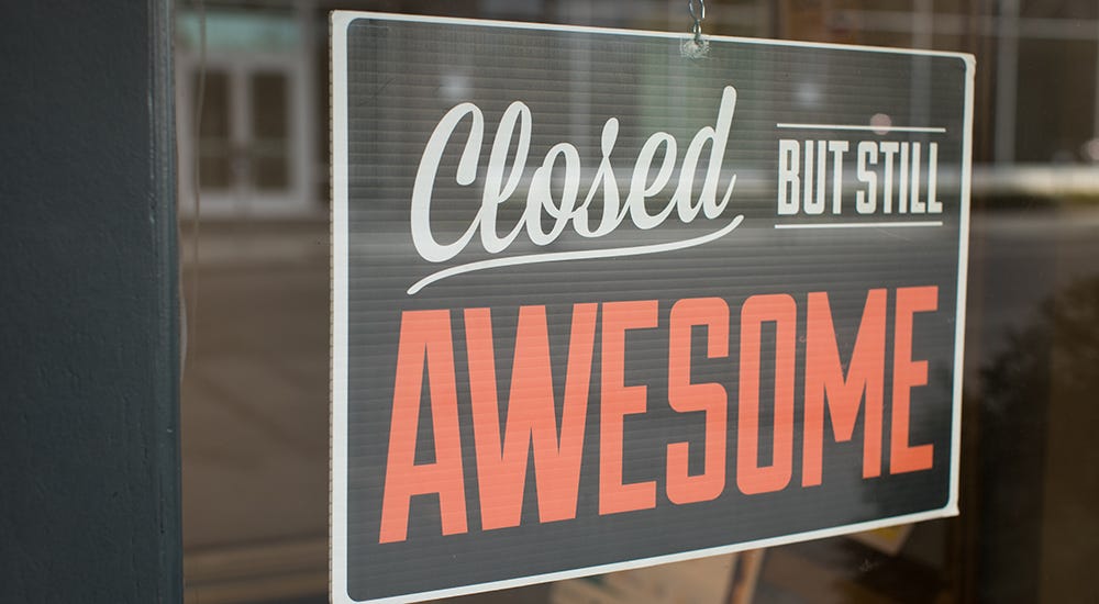 foto van een gesloten bordje achter een raam. Er staat "closed but still awesome"