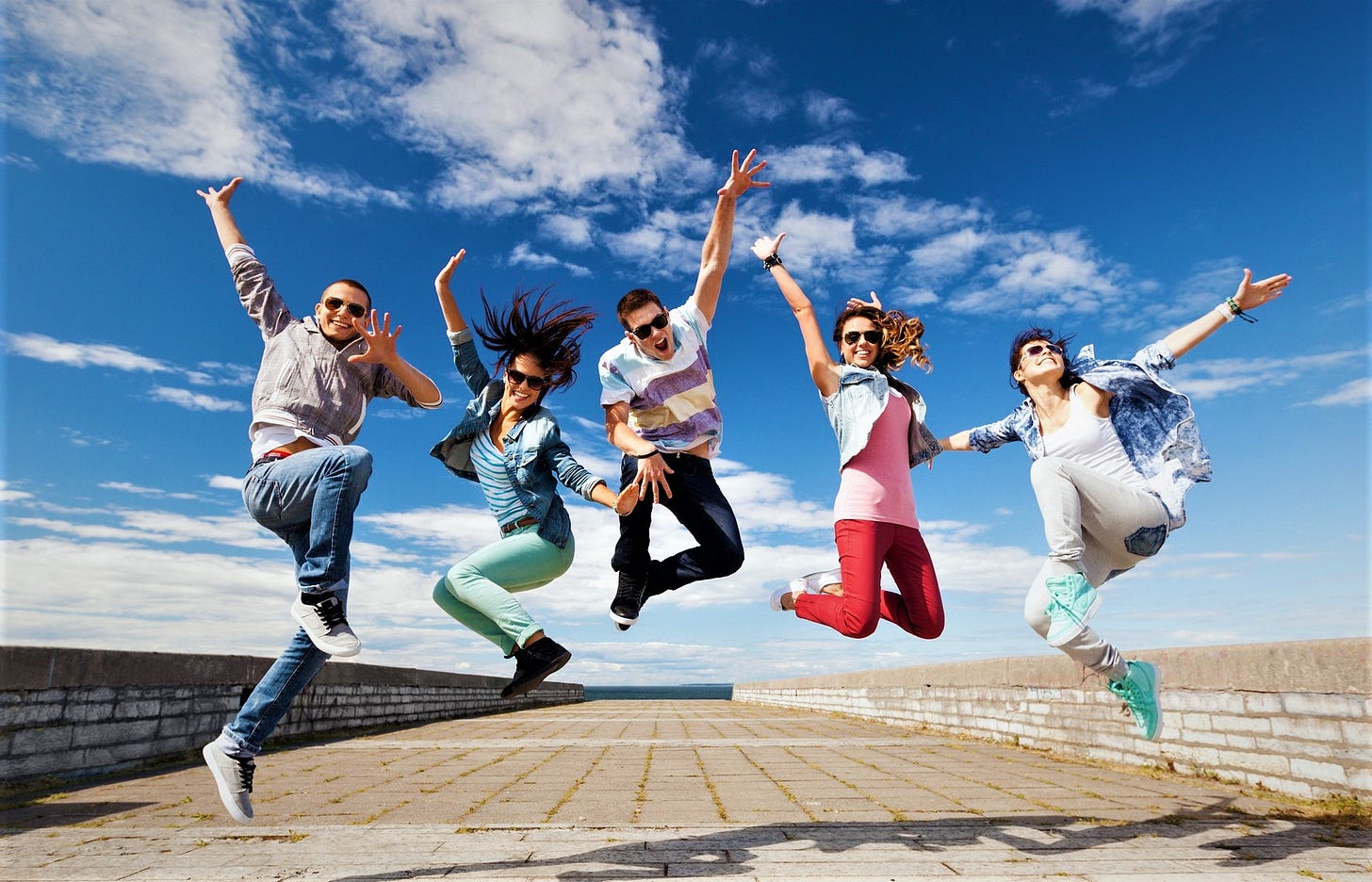 five happy excited people jumping in the air