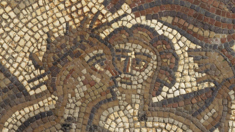 A close up of two figures in a mosaic in the Dining Room at Chedworth Roman Villa, Gloucestershire