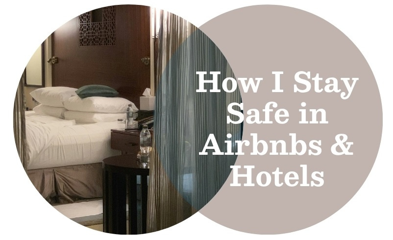 Partially-made bed with white linens and dark grey accent pillow with wood headboard and side table. Muted brown and white colors.